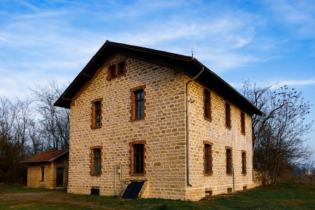 Historic stone building facade with large windows