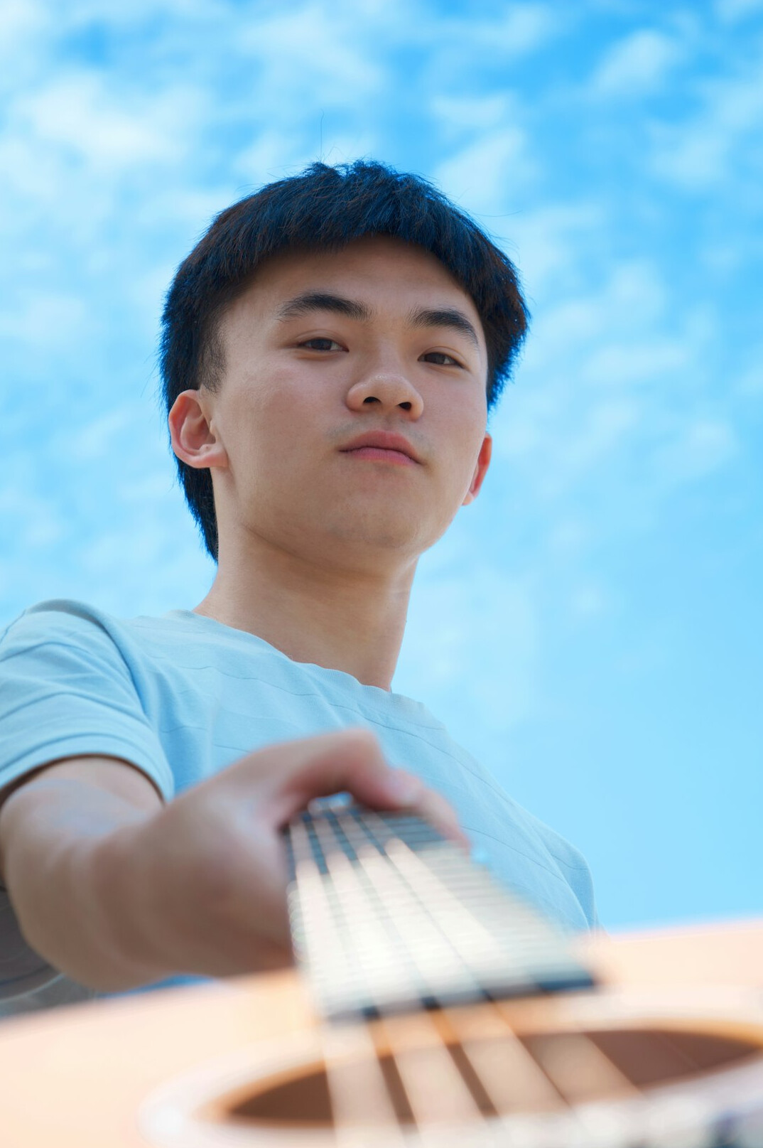 Close portrait of a young musician holding a guitar