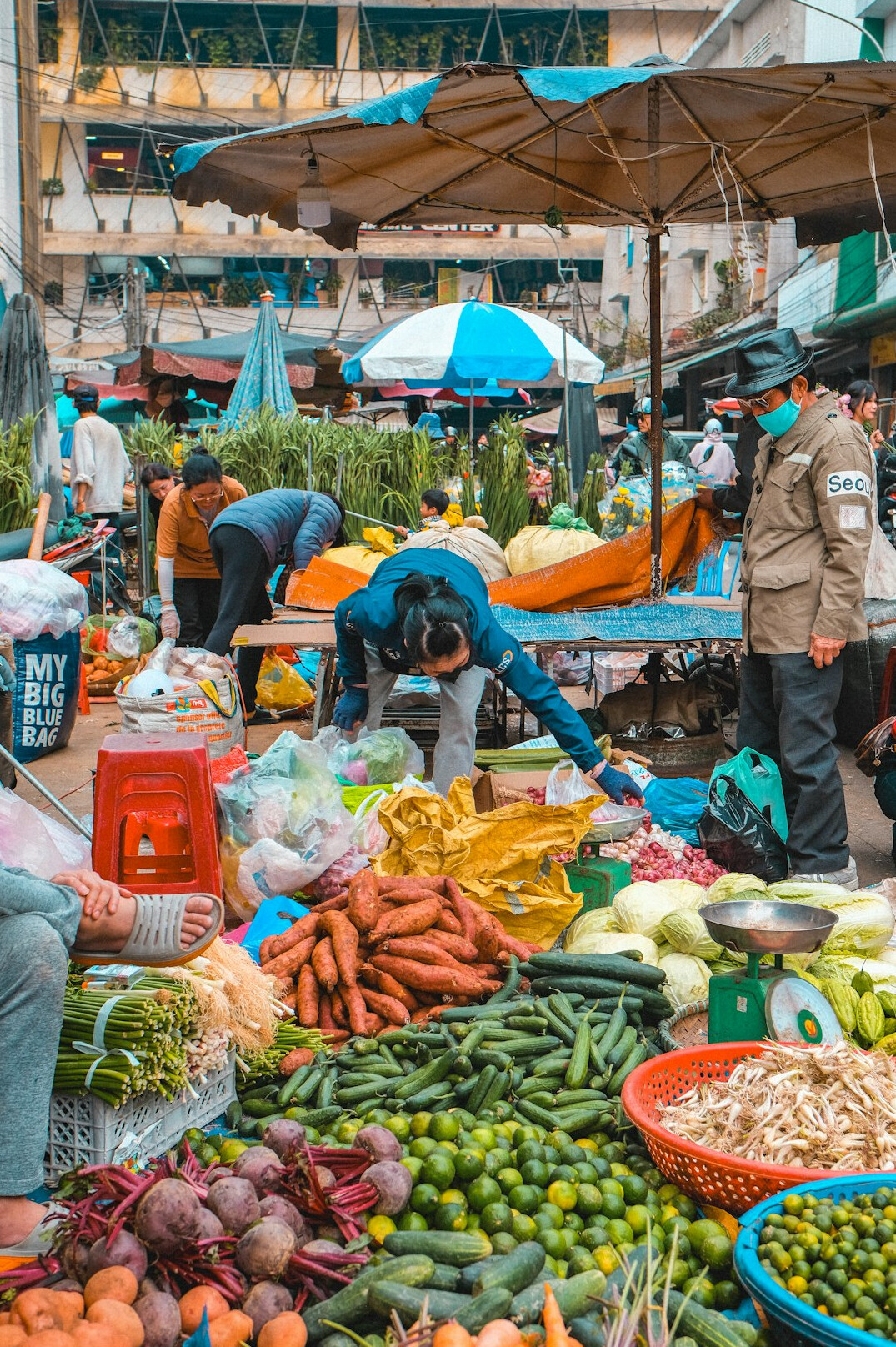 Vendor arranging produce at an outdoor market stall